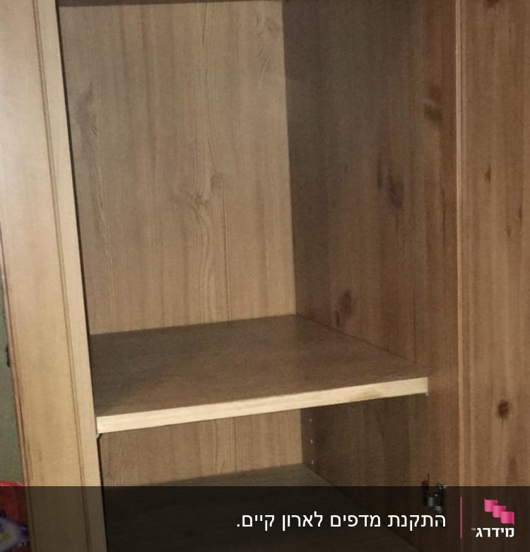 ארון עץ עם מדפים ריקים ודלת פתוחה